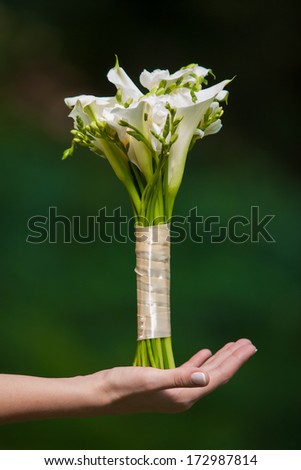 bride and groom holding a wedding bouquet of callas