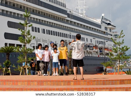 KAGOSHIMA CITY, JAPAN -OCTOBER 8: A family poses in front of the first cruise ship to dock at the newly built marine port, the ms Amsterdam October 8, 2007 in Kagoshima City, Japan