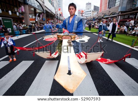 KAGOSHIMA CITY, JAPAN - JULY 19:  A participant of the Ogion festival carries  a  bamboo pole with a sword at the end July 19, 2009 in Kagoshima, Japan.
