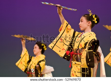 KAGOSHIMA CITY, JAPAN - OCTOBER 27, 2007:   Japanese dancers in yellow kimono perform onstage in the night portion of the Taniyama Furusato Matsuri festival October 27, 2007 in Kagoshima City, Japan.