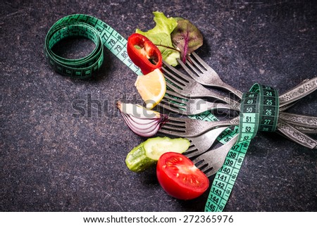 Fresh mixed vegetables on fork with measuring tape