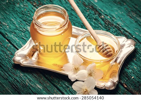 Honey and flowers on old wooden table,Vintage style