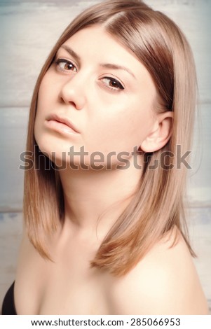 Portrait close up of young beautiful woman, on wooden background.Beauty Model Woman Face. Perfect Skin with healthy hair.Vintage style.