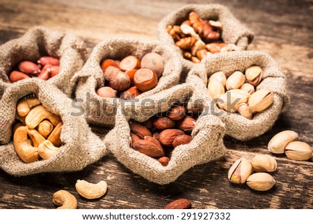 Assortment of nuts on wooden old table,healthy vegan food.