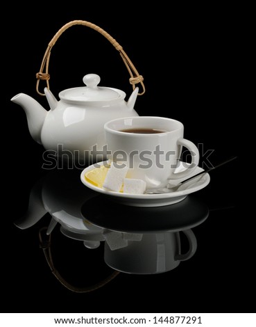 Black tea in white dishware on black reflecting background