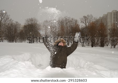 Boy throws up fresh snow in city winter park