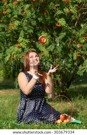 Happy and healthy girl with red apple in the park