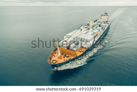 Aerial view of cargo ship sailing in open sea