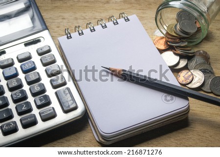 note pad, pencil, coins and calculator