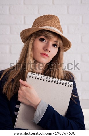 Attractive young woman with  notebook in summer hat