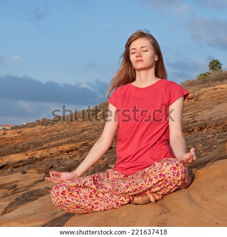 Young woman meditation in mountains on sunrise
