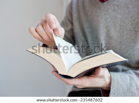 Man holding an open book in hands