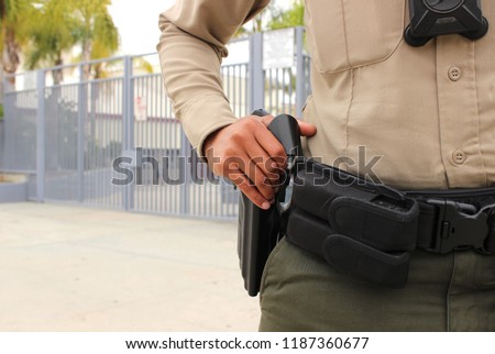 School safety concept - armed police officer on duty protecting a closed campus high school in California