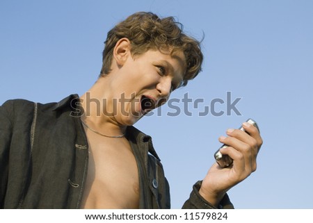 Teenager with telephone in hand on sky background