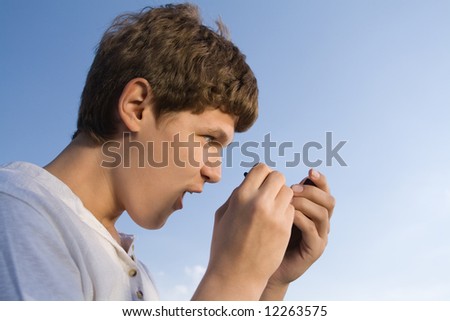 Teenager with telephone in hand on sky background