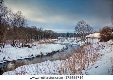 Winter landscape with river and snowy field