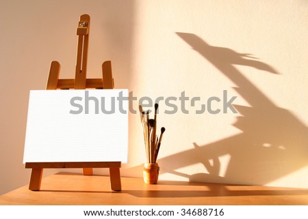 stock photo : Table easel with canvas and brushes