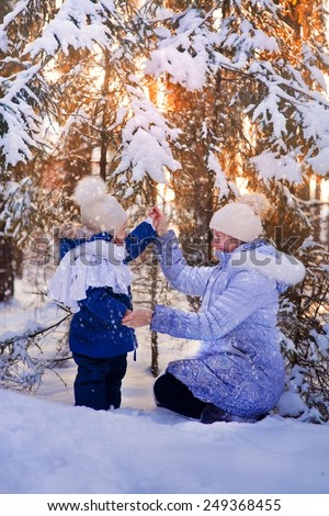 Portrait of mother and baby in sunny winter forest