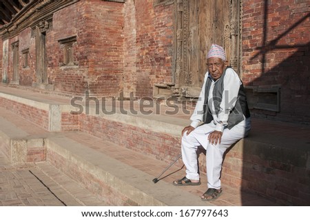 PATAN, NEPAL - NOVEMBER 5 : An old man resting in the historical city of Patan, Nepal on November 5, 2012. Patan is best known for its rich cultural heritage, especially its arts and crafts