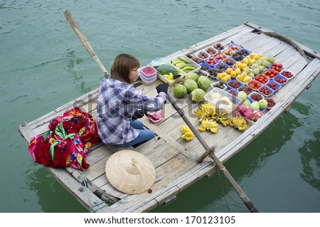 HA LONG BAY, VIETNAM - MAY 25: Unidentified woman sells fruits from her boat on Ha Long bay, Vietnam on MAy 25, 2011. Floating markets are very popular as it is only way to move around.