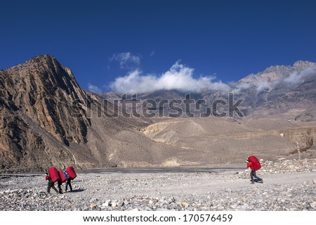 Mountain porters carrying heavy load in Himalayas, Nepal
