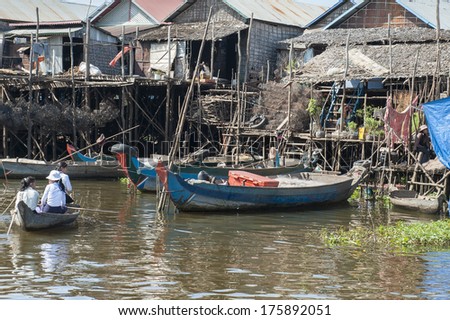 TONLE SAP, CAMBODIA - DECEMBER 24, 2011: Unidentified people ride a boat in floating village on Tonle Sap lake. It is the largest lake in Southeast Asia (up to 16,000 square km).