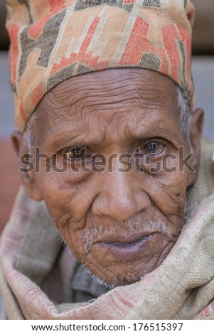 PATAN, NEPAL - MARCH 29: Unidentified Nepali old man with traditional Topi hat poses for camera in Patan, Nepal on March 29, 2013.