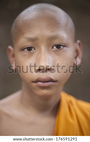 SIEM REAP, CAMBODIA - DEC 29: An unidentified monk poses for a photo on December 30, 2012 in Siem Reap, Cambodia. His lips similar with buddha statue lips at Bayon temple, Angkor Wat.