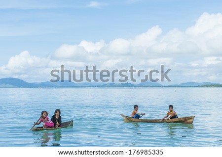 OMADAL ISLAND, SABAH, MALAYSIA - JANUARY 28 : Unidentified Sea Gypsies kids paddles a boat on January 28, 2012 in Sabah, Malaysia. The Sea Gypsies are sea nomads that move from one place to another.
