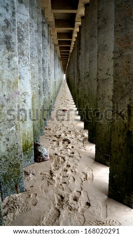 Row of columns on the sandy seaside
