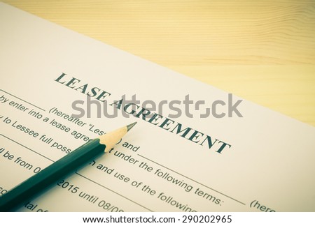Lease Agreement Contract Document and Pencil Bottom Left Corner on Wood Table in Vintage Style. Legal document for business event