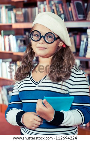 Intelligent girl in glasses holding a book