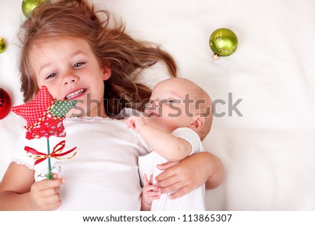 Elder sister and newborn baby playing with  Christmas star