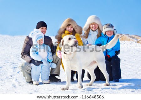 White winter labrador dog and family beside him