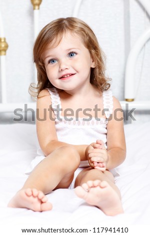 Sweet thoughtful little girl sits in bed