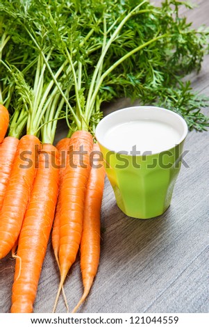 Closeup shot of fresh carrots and glass with milk