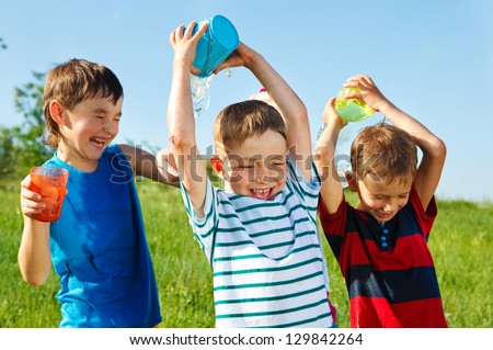 Happy Boys With Plastic Containers Splashing Water Over One Another\'S Heads