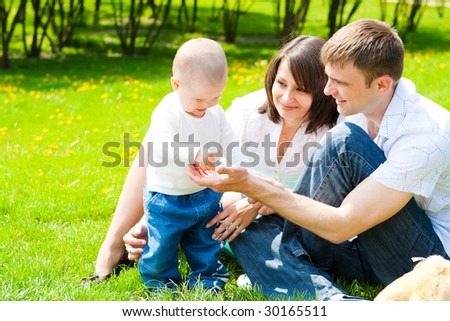 Happy family sitting in the summer park