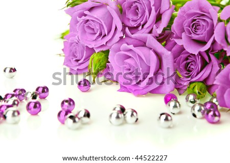 Purple roses bouquet and beads on white background