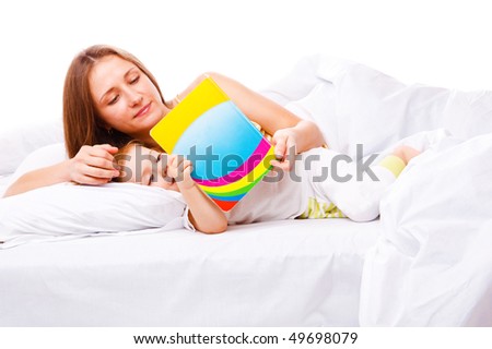 Mom reading a book to her daughter in bed