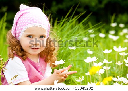 Happy girl  on the meadow with white flowers