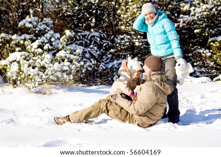 Happy attractive family playing in snow