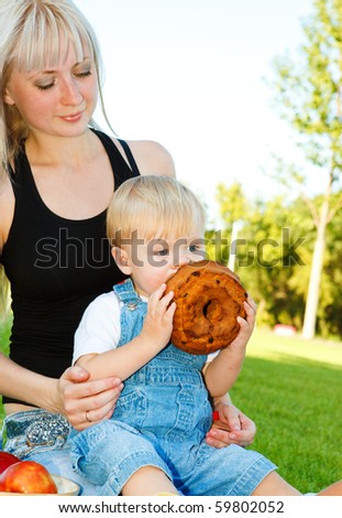 Young mother with baby son eating cake