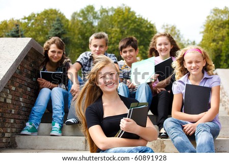 stock photo Attractive teenagers with books laughing
