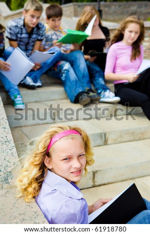 Students with books sitting on a stairway