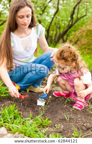 Mother and daughter working in garden