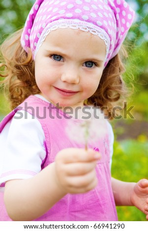 A sweet girl in the garden, with dandelion