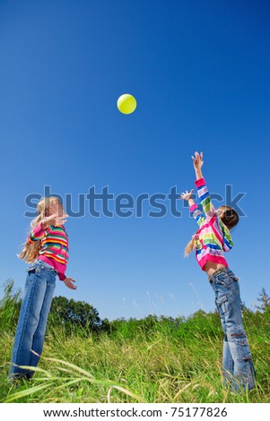 Two girls catching and throwing ball