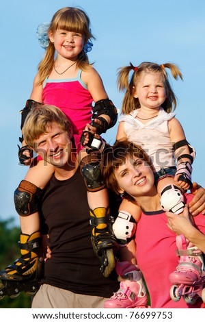Happy parents holding children in roller skates