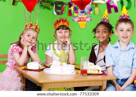 Sweet friends sitting at the table and eating  birthday cake